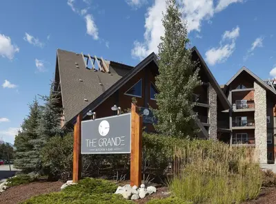 a building with a sign in front of it at Sundance Suite - Beautiful Condo With Open Pool And Hot Tub in Canmore