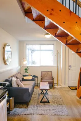 a living room with a couch and a table at Mid-Island Getaway - Sunken Hot Tub & Deck - Close to Beach - Modern in Nanaimo