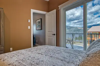 a bedroom with a bed and a large window at Semi-Lakefront Luxury Retreat In Blind Bay, Bc Cottage in Blind Bay