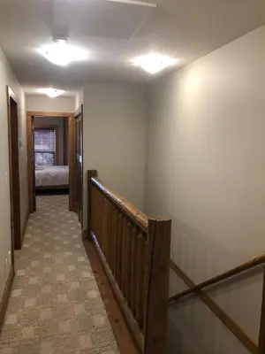 a hallway with a staircase with a bed in a room at Lakefront Townhouse Family Complex, Popular Wine Country and the Best Golfing in Osoyoos
