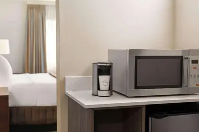 a microwave and a coffee mug sitting on a counter at Travelodge by Wyndham Calgary South in Calgary