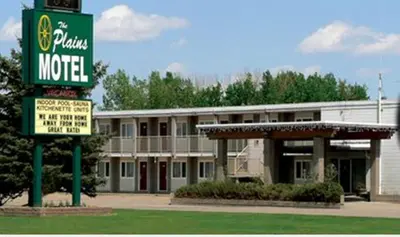 a motel with a sign in front of a building at Plains Motel in Brooks