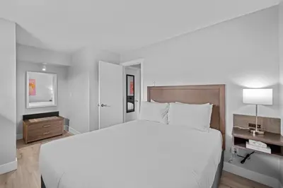 a bedroom with a large white bed and a television at The Vista Inn in Kamloops