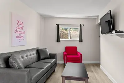 a living room with a couch and a red chair at The Vista Inn in Kamloops