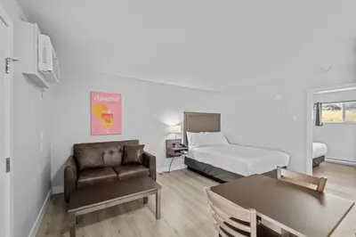 a bedroom with a bed and a couch and a chair at The Vista Inn in Kamloops