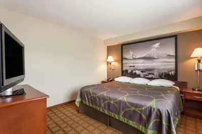 a hotel room with a bed and a flat screen tv at Super 8 by Wyndham Abbotsford BC in Abbotsford