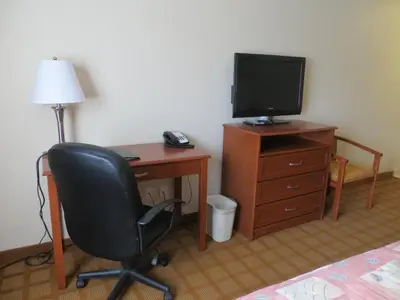 a room with a desk with a chair and a television at Super 8 by Wyndham Abbotsford BC in Abbotsford