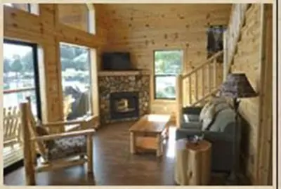 a living room with a bed and a fireplace at Brown's Bay Resort in Campbell River