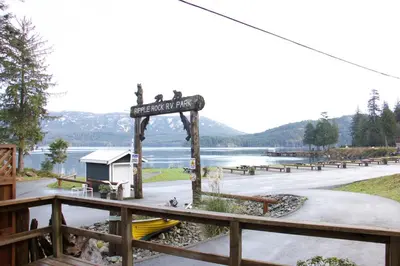 a sign at a park with a lake in the background at Brown's Bay Resort in Campbell River