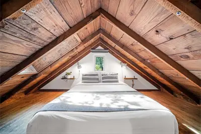 a bedroom with a bed in the attic at Sunwolf Riverside Cabins in Brackendale