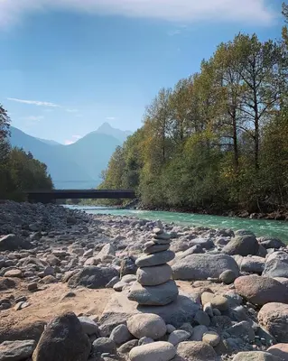 a stack of rocks sitting on a rocky river at Sunwolf Riverside Cabins in Brackendale