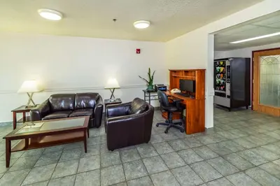 a living room with a couch and a table and a television at Rodeway Inn in Edson