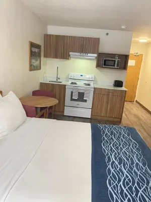 a hotel room with a bed and a kitchen at Rodeway Inn in Edson