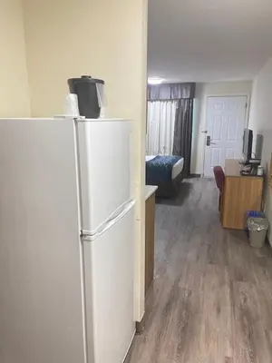 a white refrigerator in a room with a bedroom at Rodeway Inn in Edson
