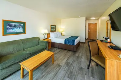 a hotel room with a bed and a couch at Rodeway Inn in Edson