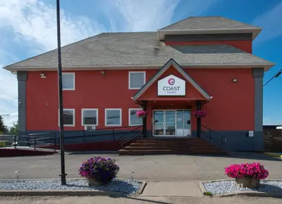 a red office building with a sign on it at Coast Fort St John Hotel in Fort Saint John