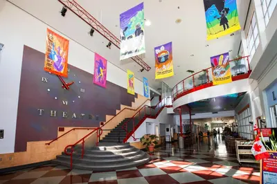 a lobby with a staircase in a building at Coast Fort St John Hotel in Fort Saint John