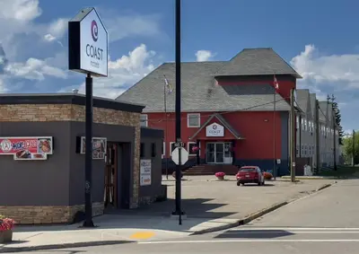 a street sign in front of a building at Coast Fort St John Hotel in Fort Saint John