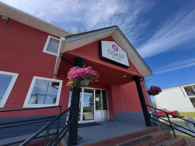 a red building with a coles sign on it at Coast Fort St John Hotel in Fort Saint John