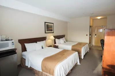 a hotel room with two beds and a microwave at Lakeview Inns & Suites - Chetwynd in Chetwynd