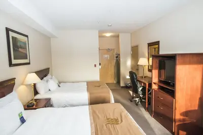 a hotel room with two beds and a flat screen tv at Lakeview Inns & Suites - Chetwynd in Chetwynd