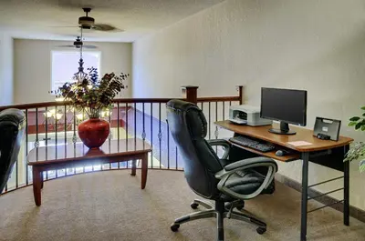 an office with a desk with a computer and a chair at Lakeview Inns & Suites - Chetwynd in Chetwynd