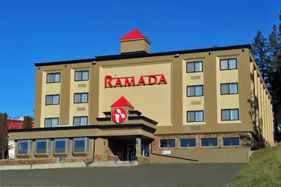 a hotel with a karma sign on the front of it at Ramada by Wyndham Williams Lake in Williams Lake