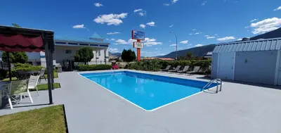 a swimming pool in a yard with chairs around it at Grand Forks Inn in Grand Forks