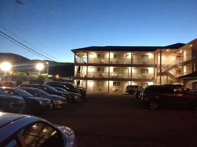 a parking lot with cars parked in front of a building at Motel 99 in Grand Forks