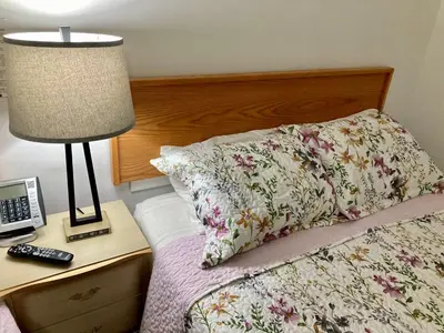 a bedroom with a bed with a lamp and a phone at Motel 99 in Grand Forks