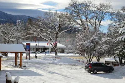 a car parked in a parking lot covered in snow at Western Traveller Motel in Grand Forks
