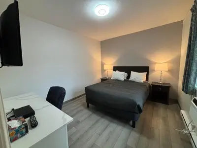 a hotel room with a bed and a desk with a desk at Western Traveller Motel in Grand Forks
