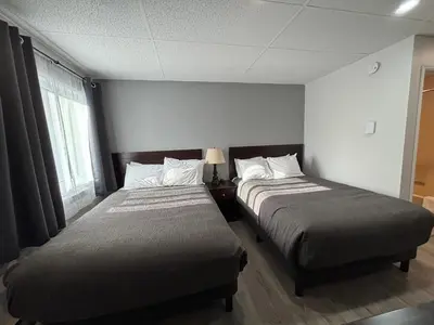 a bedroom with two beds and a window at Western Traveller Motel in Grand Forks