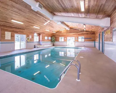 a large swimming pool in a building with a wooden ceiling at Quality Inn Merritt in Merritt