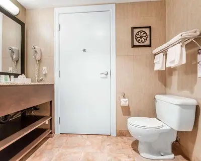 a bathroom with a white toilet and a sink at Quality Inn Merritt in Merritt