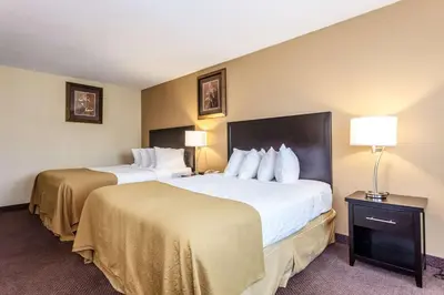 a hotel room with two beds and two lamps at Quality Inn Merritt in Merritt