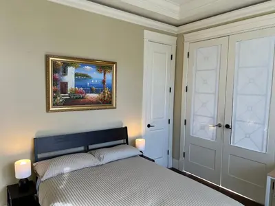 a bedroom with a bed and a painting on the wall at Mike's Luxury House in Vancouver