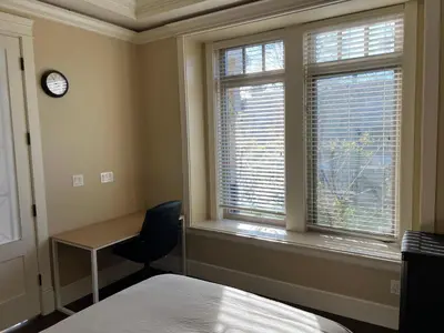 a bedroom with a desk and a bed and a window at Mike's Luxury House in Vancouver