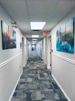 an empty hallway in an office building with paintings on the walls at Elite Hotel -Downtown Center- 