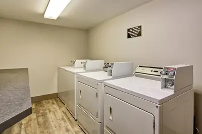 a kitchen with white counters and appliances in a room at Canalta Brooks in Brooks