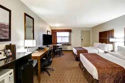 a hotel room with two beds and a desk at Canalta Hanna in Hanna
