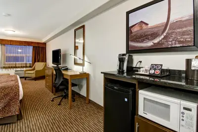 a hotel room with a bed a desk and a tv at Canalta Hanna in Hanna