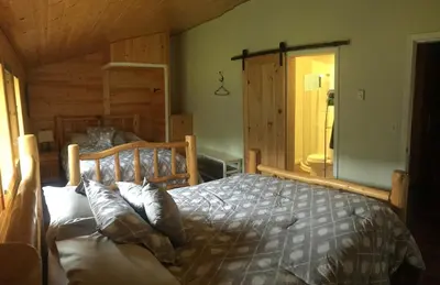 a bedroom with a wooden bed in a room at Cougar Mountain Lodge and Resort Cabin Rentals in Valemount