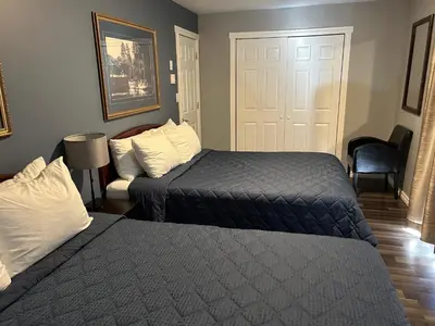 a hotel room with two beds and a door at Arrow Lake Motel in Fauquier