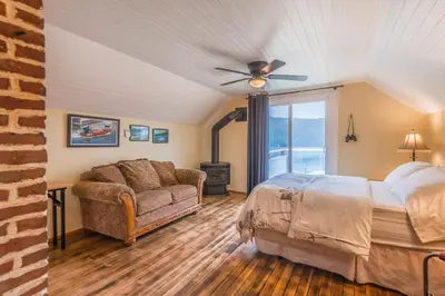 a bedroom with a bed and a couch and a ceiling fan at Outdoor Lovers in Port Alberni