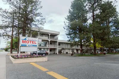 a hotel with a motel sign in a parking lot at Beachside Motel in Penticton