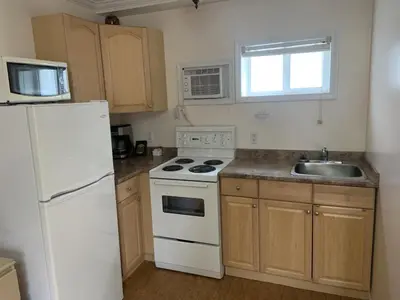 a kitchen with a white stove and a sink at Beachside Motel in Penticton