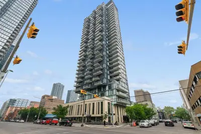 a tall building on a city street with cars at GlobalStay Modern Condos Downtown Calgary in Calgary