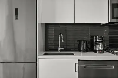 a kitchen with white cabinets and a sink at GlobalStay Modern Condos Downtown Calgary in Calgary