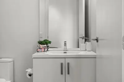 a white bathroom with a sink and a toilet at GlobalStay Modern Condos Downtown Calgary in Calgary